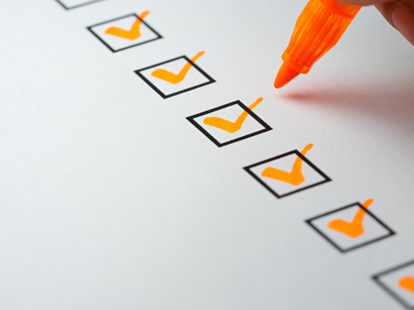 orange pen being used to tick off check boxes